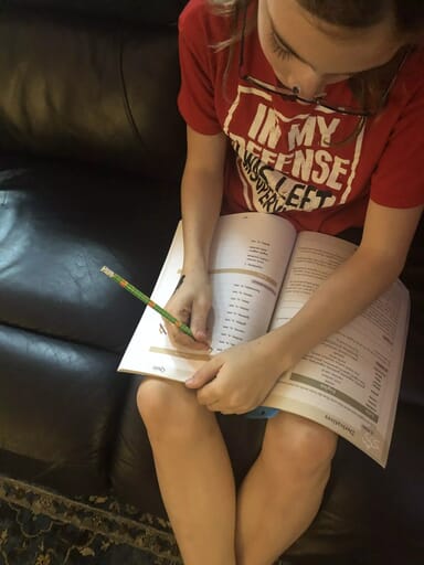 Latin for Children * Homeschool Curriculum Review Child thinking hard while he works in his Latin for Children workbook.