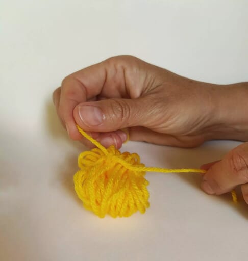 Tie a strand of yarn around the middle of your yarn ball.